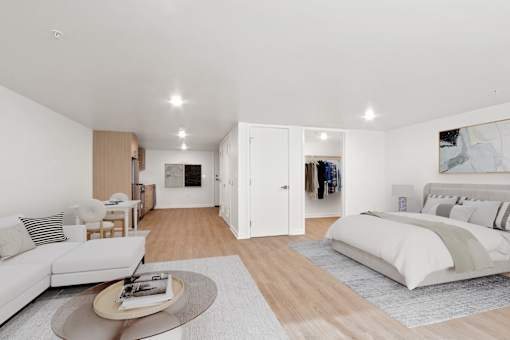 A modern bedroom with a large bed and a living area.