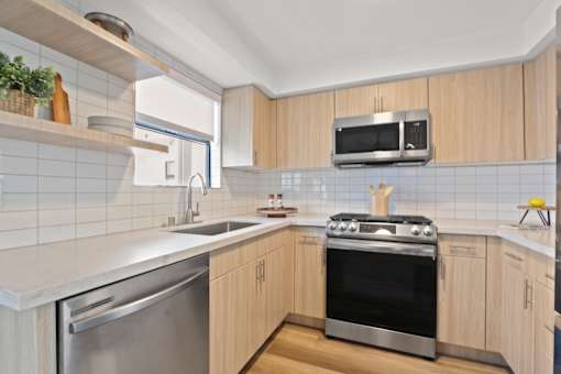 A modern kitchen with wooden cabinets and stainless steel appliances.