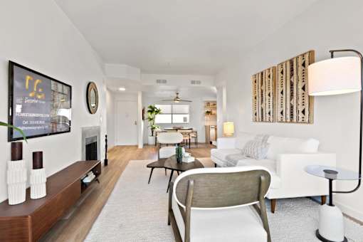 A living room with a white couch and a wooden chair.