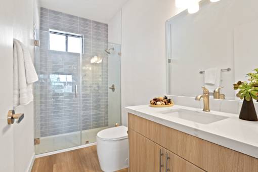 A bathroom with a toilet, sink, and shower.