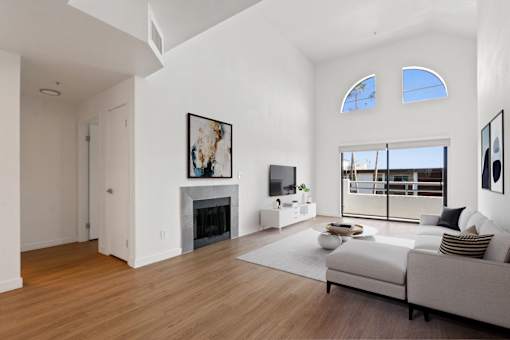A modern living room with a fireplace and a large window.
