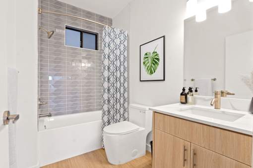 A bathroom with a toilet, sink, and shower.