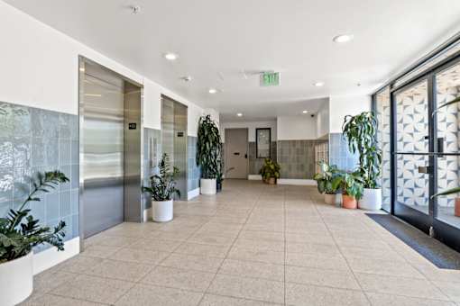 A hallway with a green exit sign above the door.