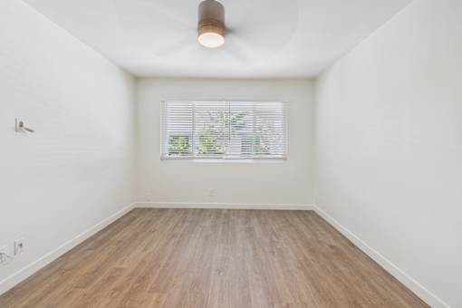 A room with a window and wooden flooring.