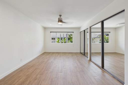 A room with wooden flooring and a ceiling fan.