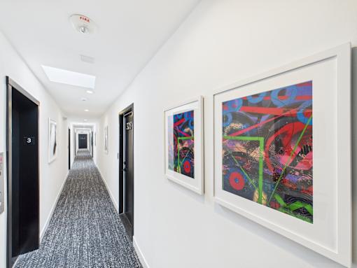 A hallway with two paintings on the wall.