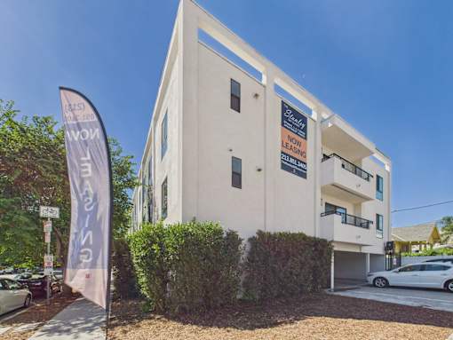 A white building with a sign that says "Now Leasing" is shown.