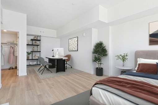 A bedroom with a bed, desk, and chair.