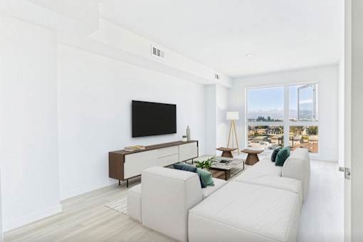 A living room with a white couch and a television.