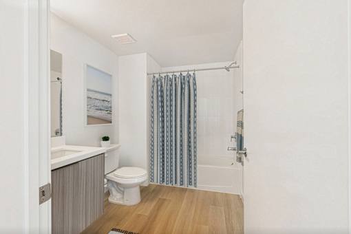 A bathroom with a toilet, sink, and shower curtain.