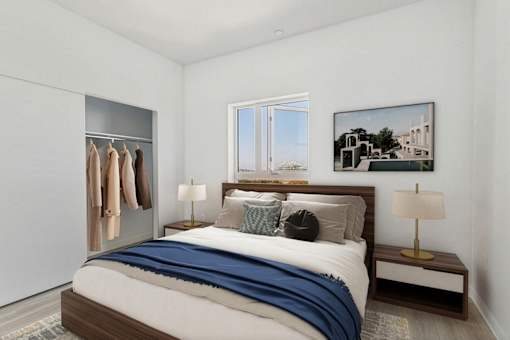 A bedroom with a bed, a bench, and a window.