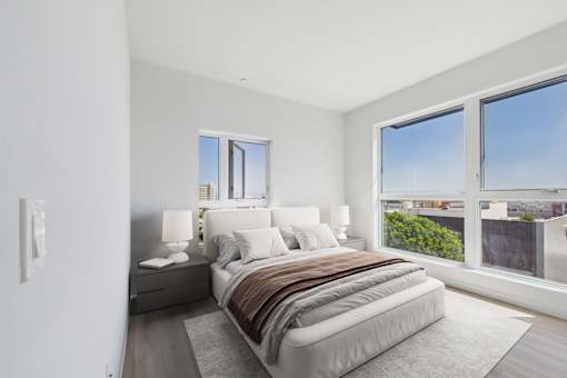A bedroom with a large bed and a view of the city.