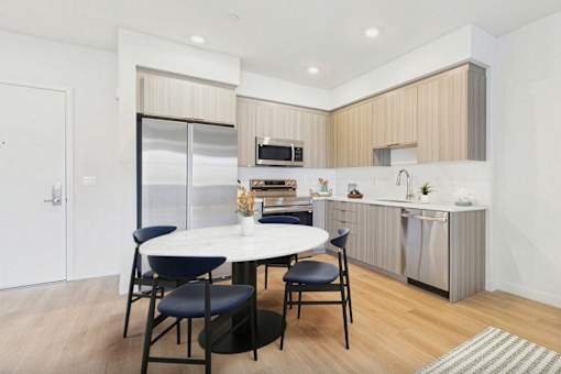 A modern kitchen with a dining table and chairs.