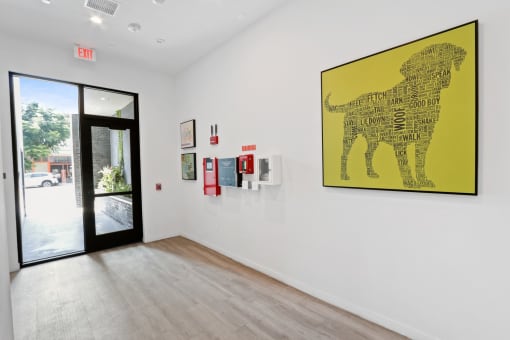 a room with a painting of a dog on the wall and a door