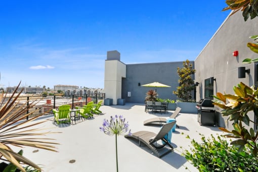 a patio with chairs and a table and an umbrella