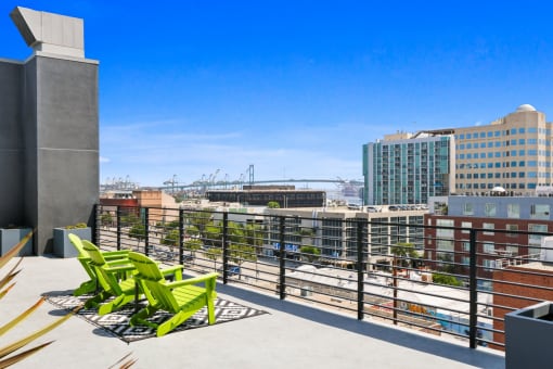 views of the city from the rooftop deck of a building with green chairs and a