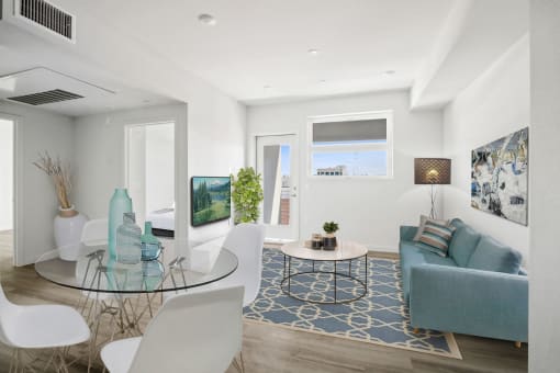 a living room with white walls and a glass table with white chairs