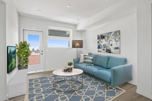 a living room with white walls and a blue couch