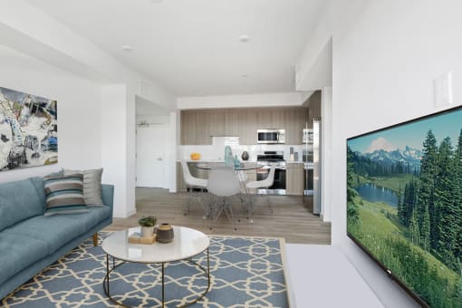a living room with a couch a table and chairs and a tv on the wall