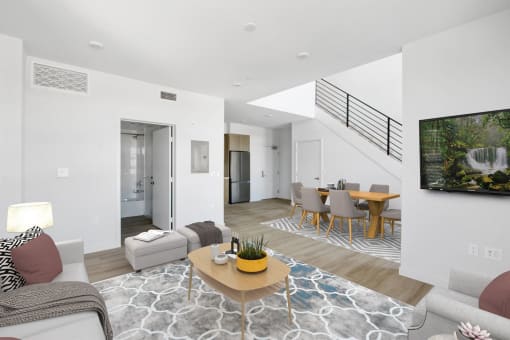 a living room and dining area with a staircase in a 555 waverly unit