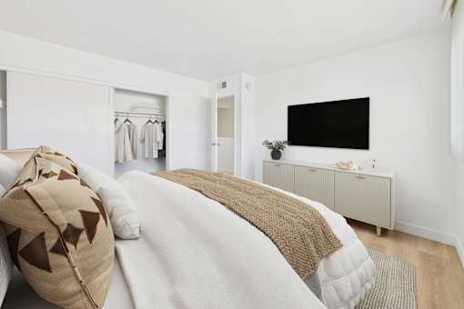A bedroom with a bed, a wardrobe, and a TV.