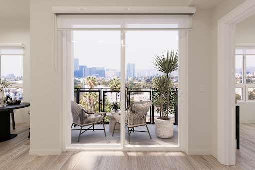 A balcony with a table and chairs overlooking a cityscape.