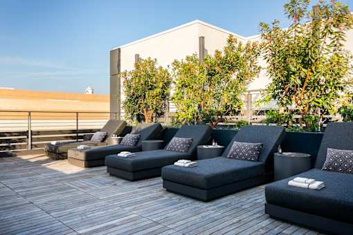 a group of lounge chairs and couches on a rooftop deck