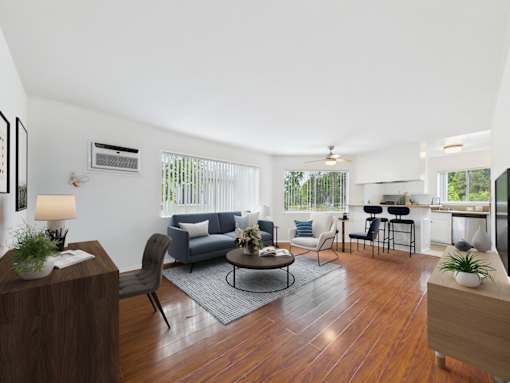 A living room with a grey couch and a wooden floor.