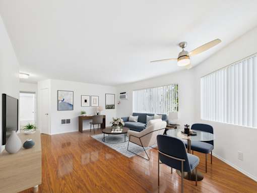 A living room with a wooden floor and a ceiling fan.