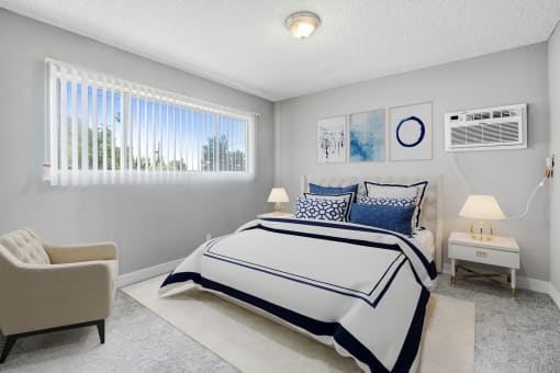 a bedroom with a bed and a chair and a window