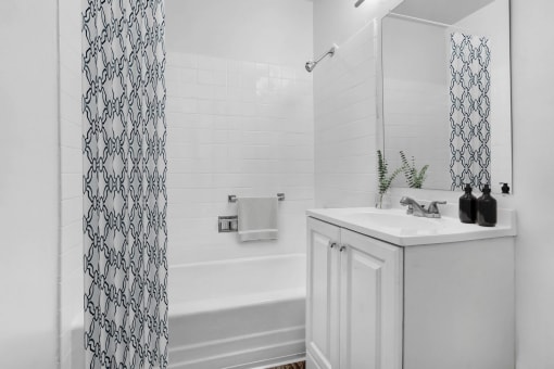a bathroom with a sink and a tub and a shower curtain
