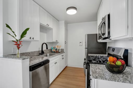 a kitchen with white cabinetry and granite countertops