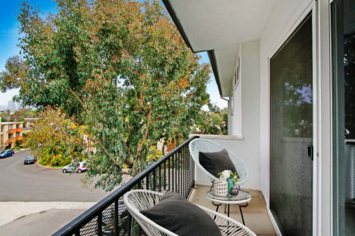 a balcony with two chairs and a table
