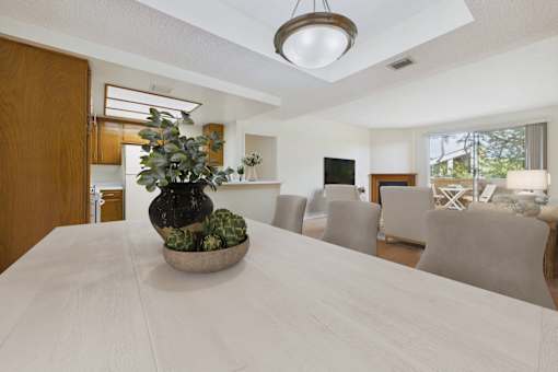 A dining table with a bowl of plants on it.