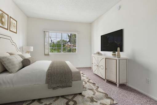 A bedroom with a bed, a dresser, and a window.