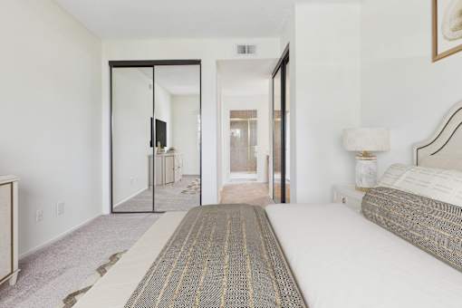 A bedroom with a bed, a dresser, and a mirror.