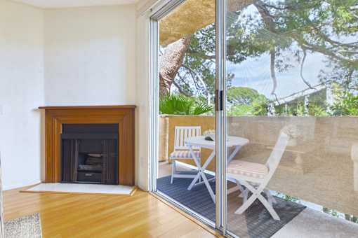 A room with a fireplace and sliding glass doors leading to an outdoor patio.