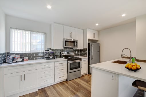 a kitchen with white cabinets and stainless steel appliances