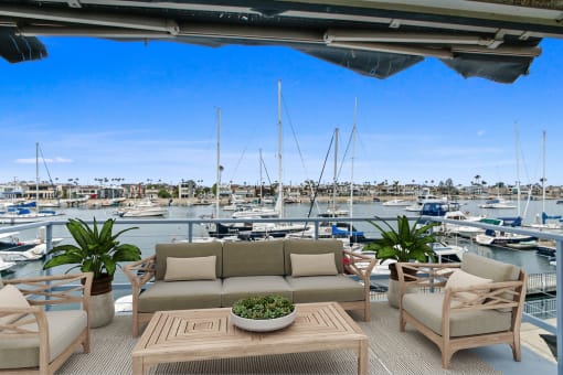 a patio with a couch and chairs overlooking a marina