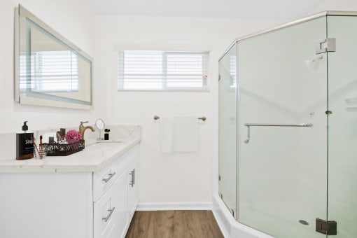 a bathroom with white walls and a glass shower
