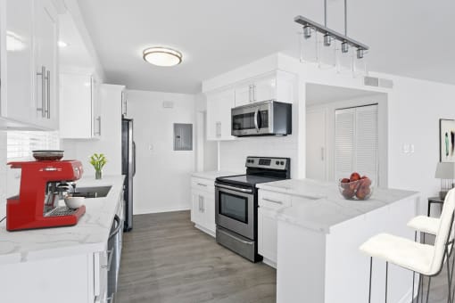 a kitchen with white cabinets and a red mixer
