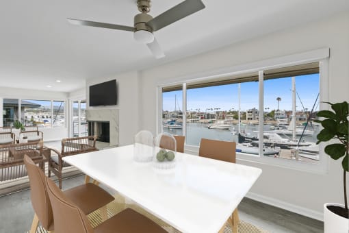 a living room with a white table and chairs and a view of a marina