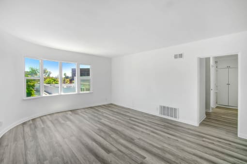 an empty living room with white walls and wood floors