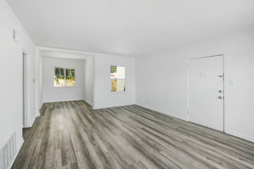a living room with white walls and wood floors