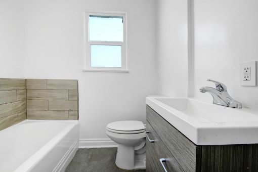 a bathroom with a toilet and a sink and a tub