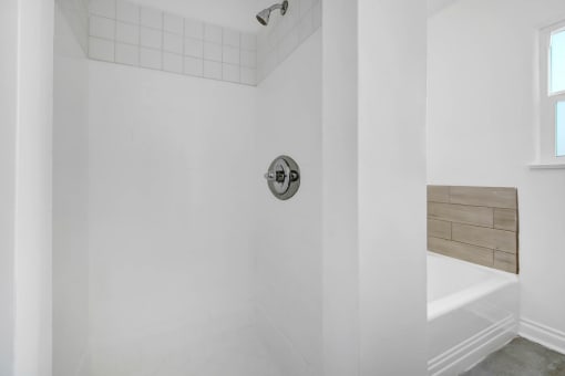a white bathroom with a shower and a tub