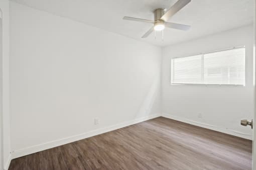 the living room of our studio apartment atrium with wood floors and a ceiling fan