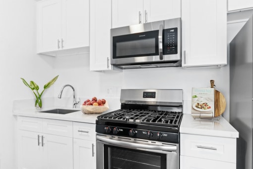 a kitchen with white cabinetry and stainless steel appliances