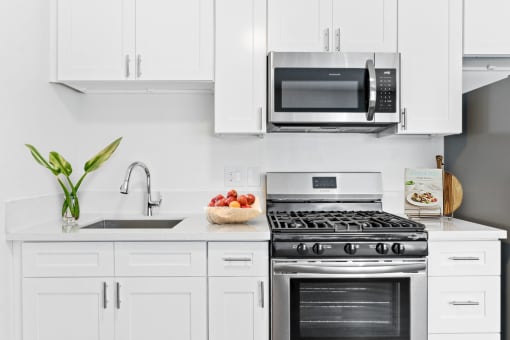 a kitchen with white cabinetry and stainless steel appliances