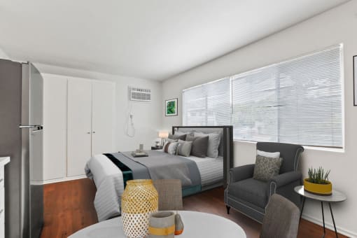 a bedroom with a bed and a chair in a room